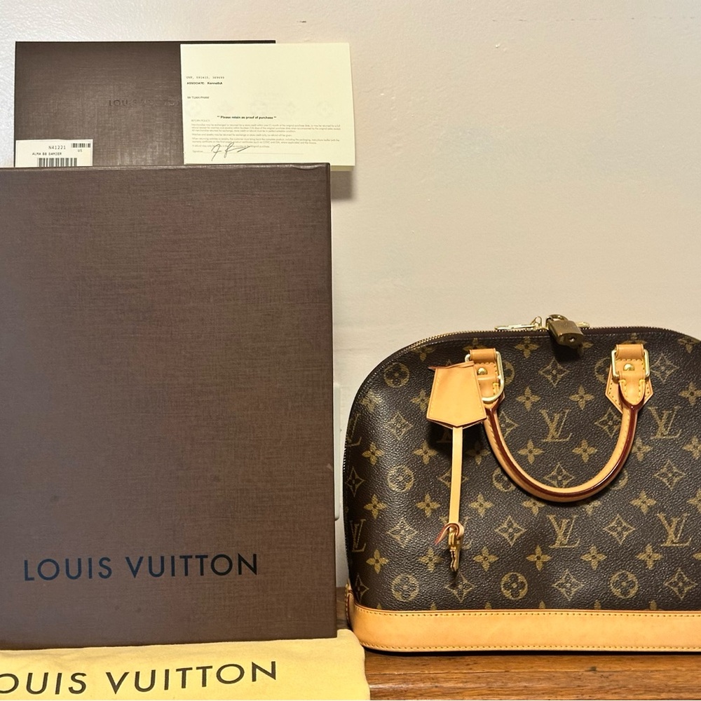 LV BAG WITH ORIGINAL BOX, DOCUMENTATION, DUST BAG, KEYS, AND LOCK.